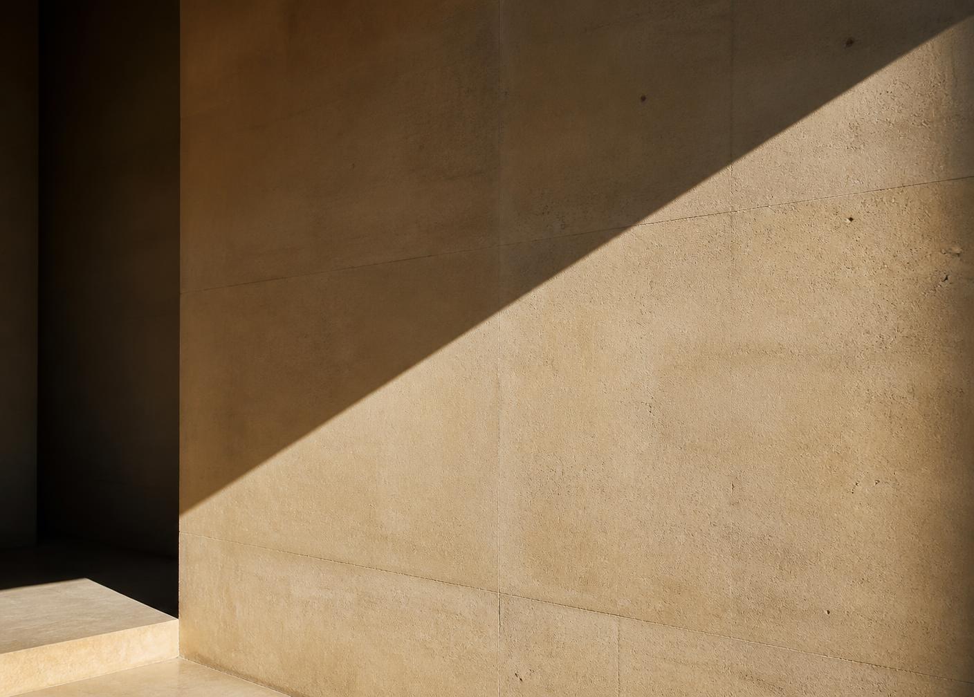 Daylight cutting through a warm concrete wall